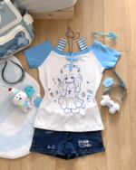 Cat Girl Nurse T-Shirt with anime character graphic, plush toys, and accessories on a wooden floor.