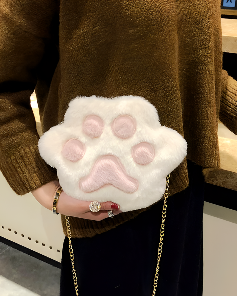 White cat paw purse displayed on a person's arm, featuring a chain strap.