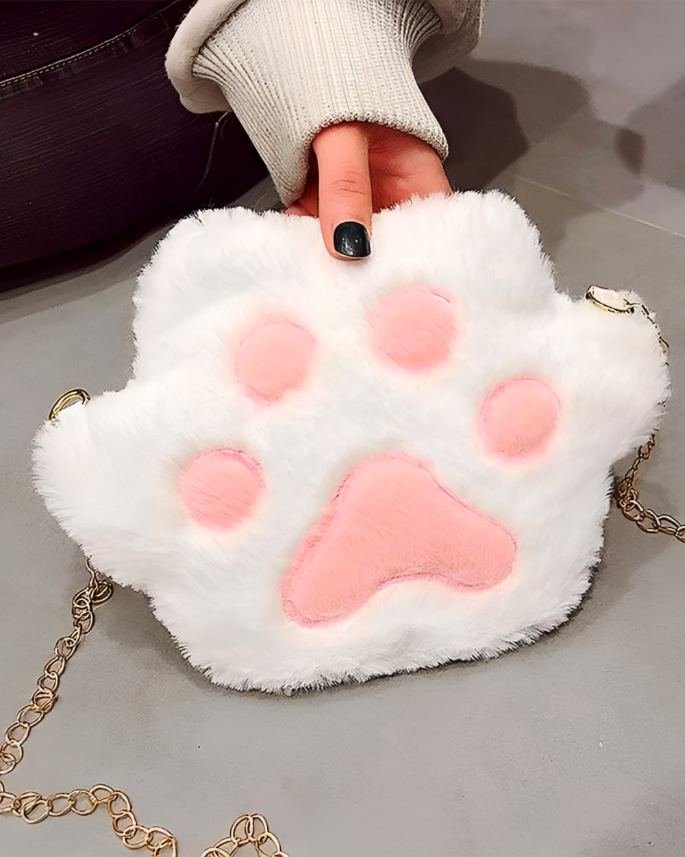 White cat paw purse with pink details, featuring a chain strap.