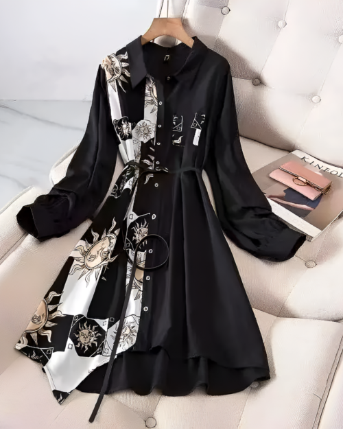 Black and white celestial witchcore dress with a sun and moon print, long sleeves, and a collared neckline. Styled on a couch.