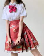 Woman wearing a white shirt and a red celestial pleated skirt with a moon and stars pattern.