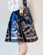 Close-up of a woman wearing a navy blue celestial pleated skirt with a detailed star and moon print.