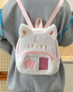 A person wearing a gray hoodie with a white Chibi Plush Backpack featuring cat ears and a front pocket with a star detail.