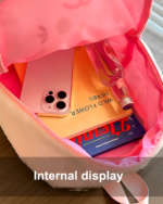 Pink Chibi Plush Backpack with a phone, bottle, and other items inside. The backpack features a Jojifuku aesthetic.