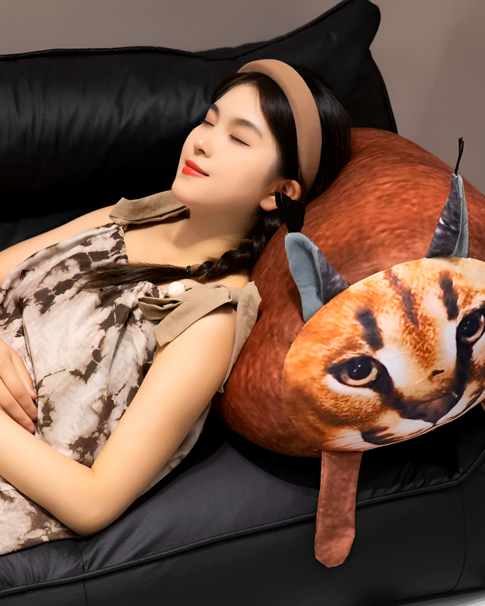 A Chonky Big Floppa plushie is nestled against a woman sleeping on a couch.