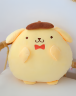 Close-up of a Chonky Purin Plushie with a brown beret and red bow tie. The plushie is yellow and features a simple, cute face.