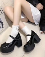 Woman wearing black Chunky Mary Janes with a platform heel and ankle buckle. Styled with white socks.