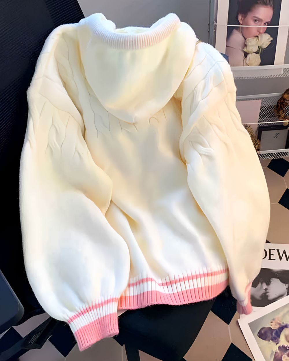 Creamy pink knit sweater, light-colored, cable knit design.