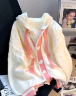 Creamy pink knit sweater featuring heart details and a cable knit design.