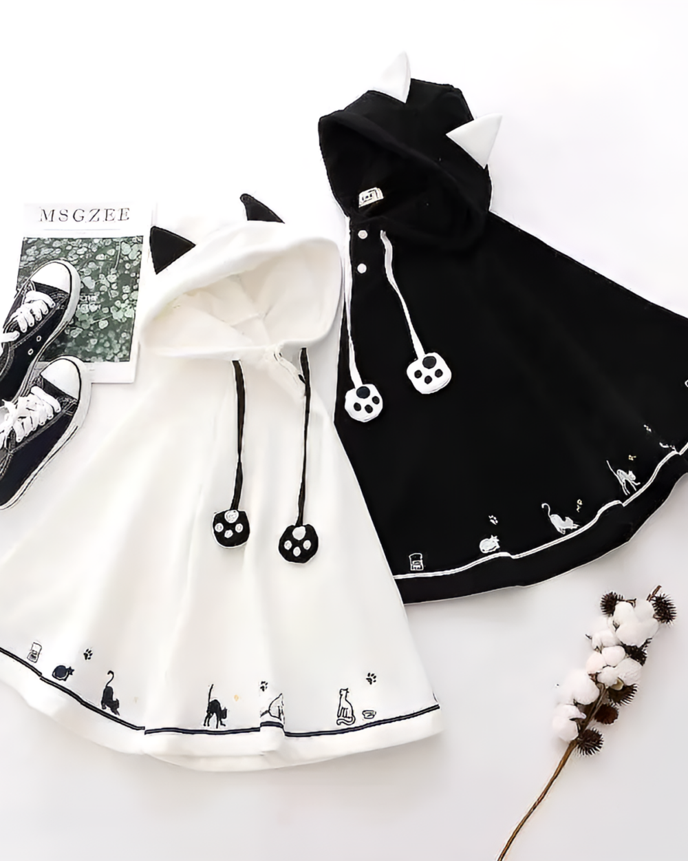 Black and white Crescent Neko-Ear Hooded Poncho with cat paw and tail designs. Ideal cozy outerwear.