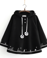 Black Crescent Neko-Ear Hooded Poncho with cat ears and paw print details. This cozy neko ear poncho is a stylish and comfortable outerwear option.