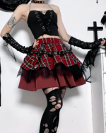 Model wearing a Crimson Strap Lace Mini Skirt. This goth punk skirt features a red plaid pattern and lace trim.