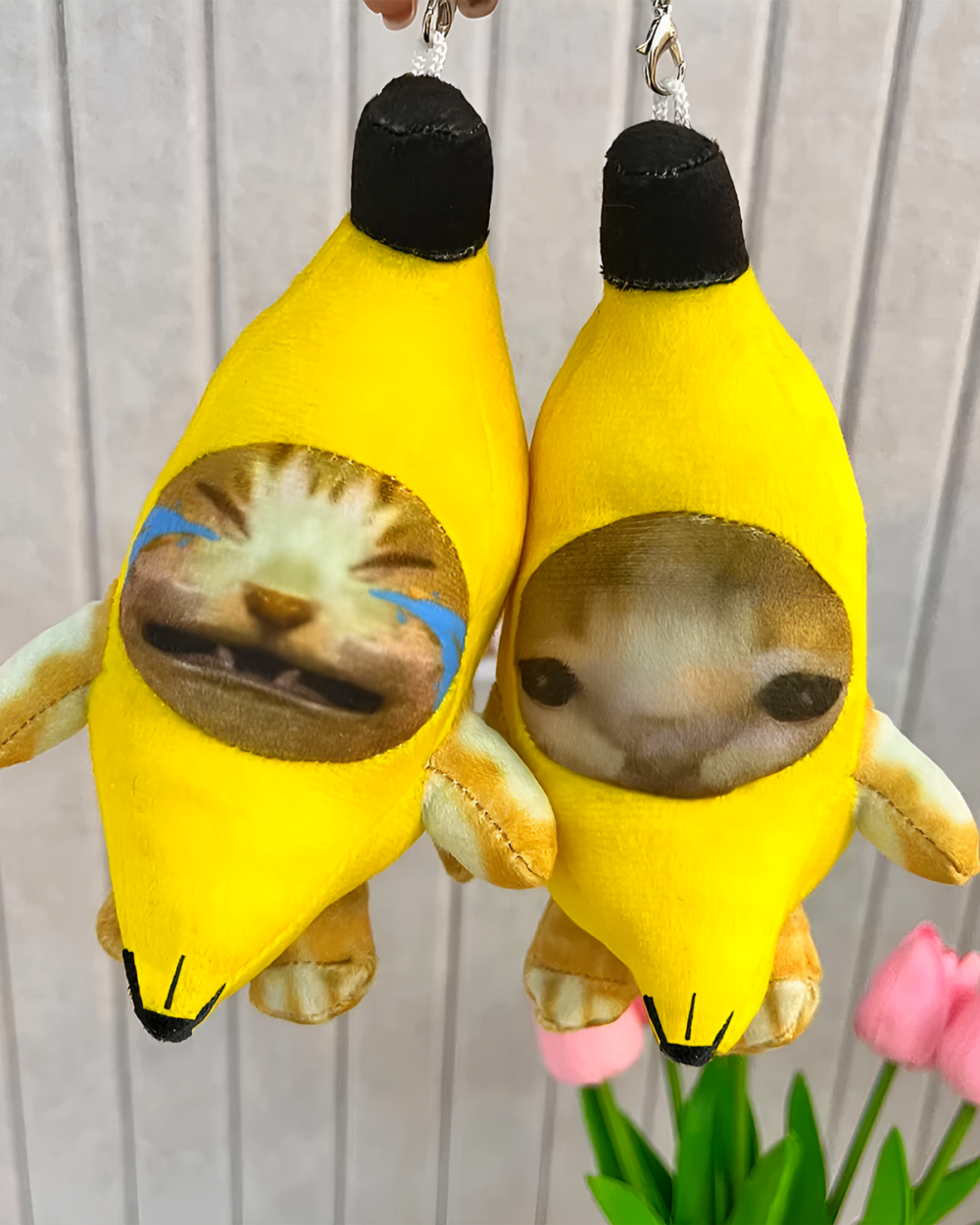 Two Crying Banana Cat bag charms, plush toys with a cat face.