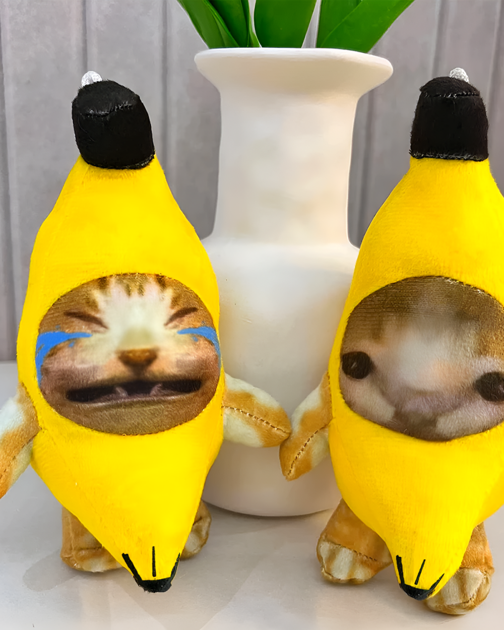 Crying Banana Cat bag charm featuring a plush banana with a cat face showing emotion.