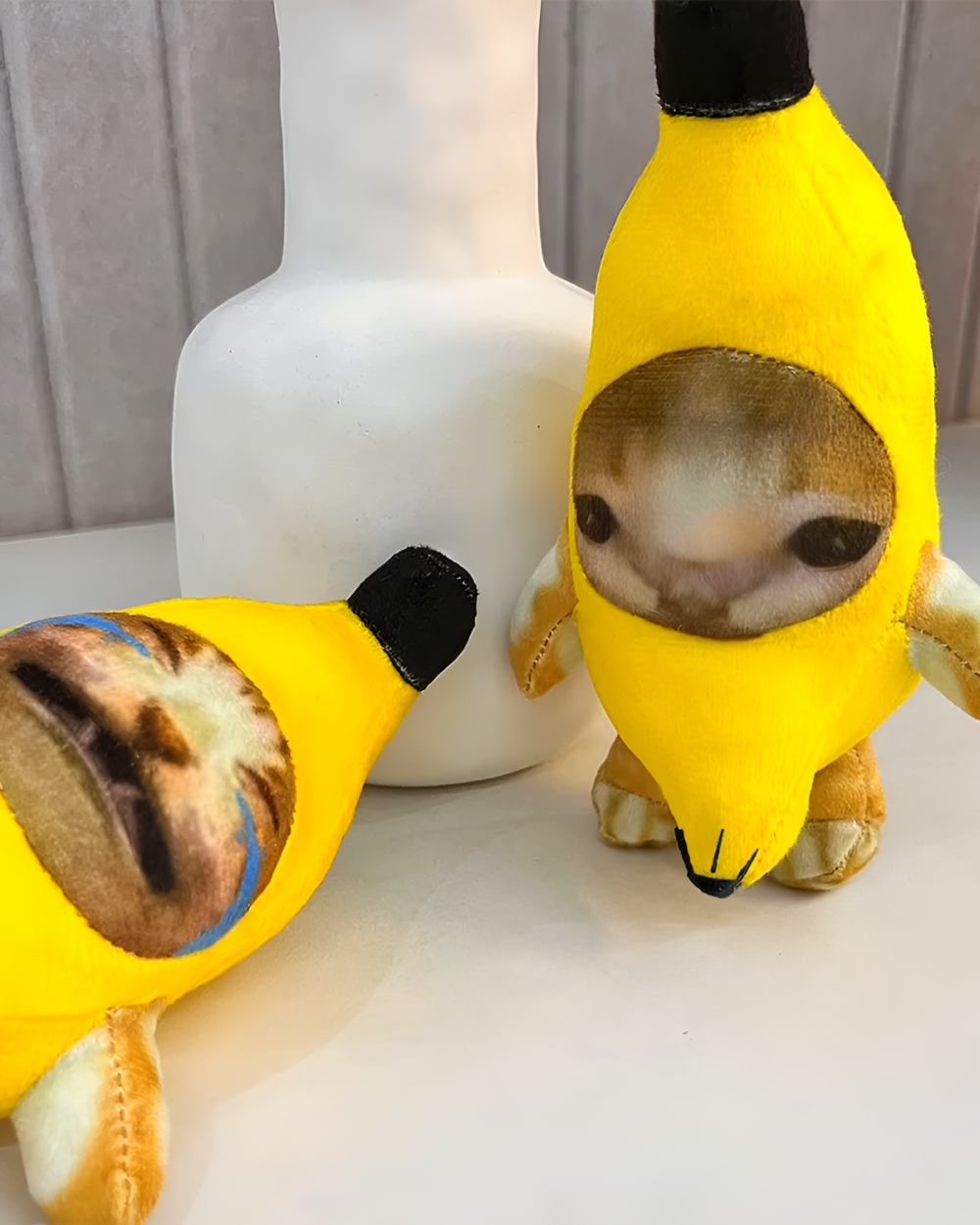 Crying Banana Cat Bag Charm featuring a plush banana with a cat face.