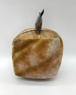 A beige Cube Floppa plushie with a textured surface and a small, dark tail.