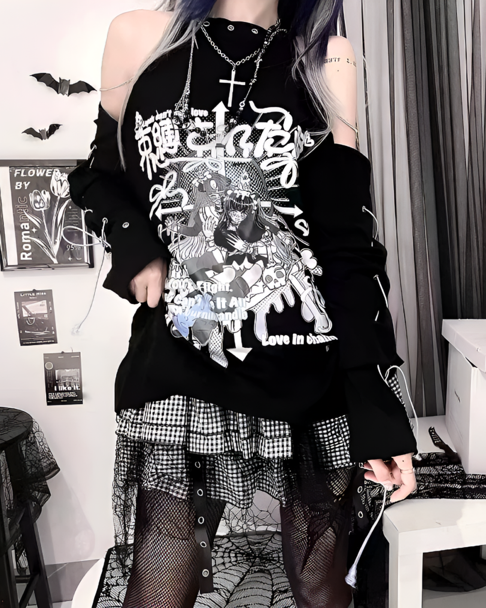 Woman wearing a black dark anime tee with Japanese text and cold shoulder design, paired with a plaid skirt and fishnet stockings.