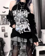 Woman wearing a black dark anime tee with Japanese text and cold shoulder design, paired with a plaid skirt and fishnet stockings.