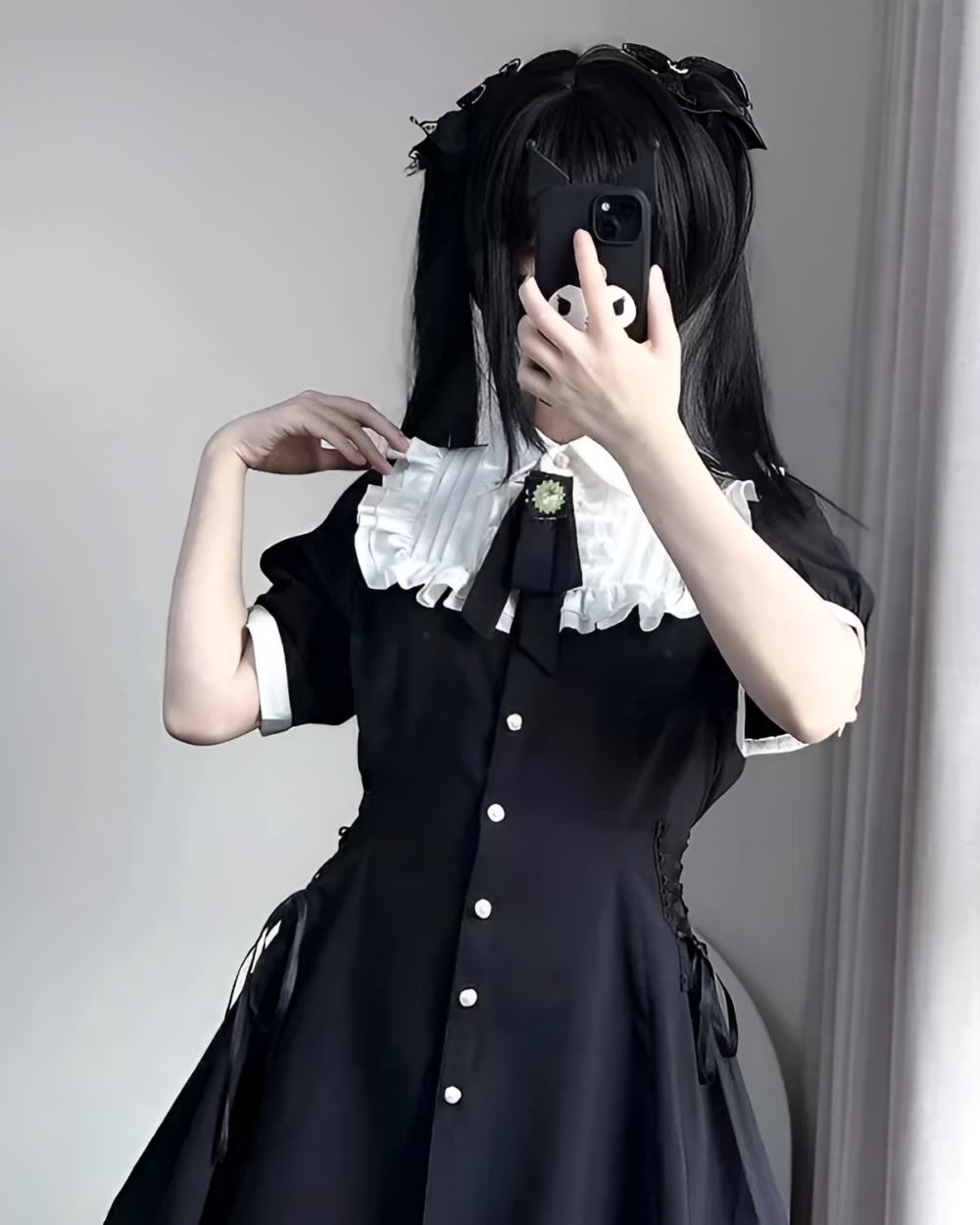 Black Girly Kei mini dress with lace collar and bow detail, featuring a phone.