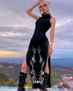Model wearing a black Dark Turtleneck Goth Dress with tribal print details, outdoors.