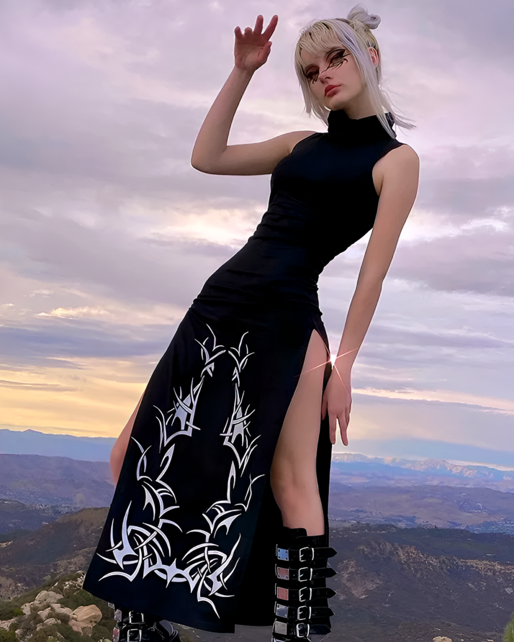 Model wearing a Dark Turtleneck Goth Dress with a high slit and tribal print, outdoors.