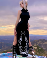 Model wearing a black Dark Turtleneck Goth Dress with intricate side detailing against a scenic mountain backdrop.