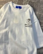 Close-up of a white t-shirt featuring the Dual Match Neko Bag T-Shirt design. Graphic of a cat face with text.