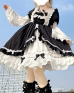 Black and white bowed maid dress with lace details and ruffles, featuring long sleeves and a layered skirt.