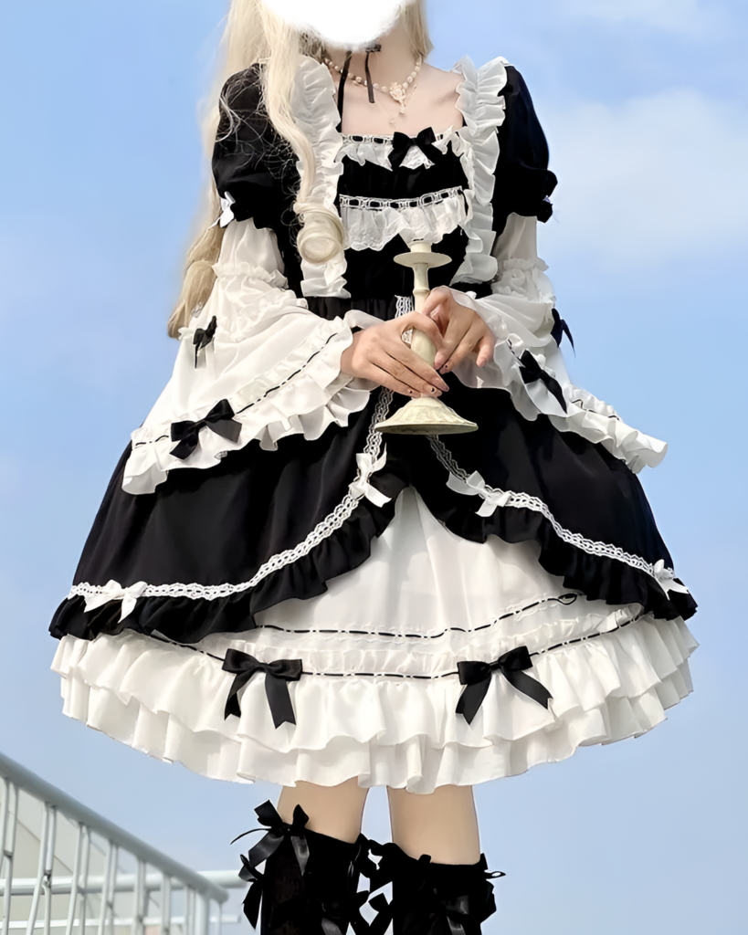 Black and white bowed maid dress with lace and ruffles, detailed sleeves and bow accents.