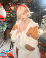 Person wearing a beige and white FFXIV Neko Coat with a red ribbon, posing indoors with holiday decorations.
