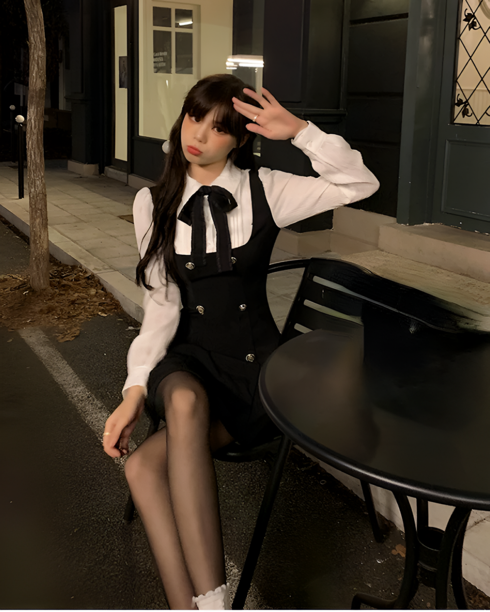 Woman wearing a black fake two-piece dress with a white shirt and suspenders, posing outdoors.