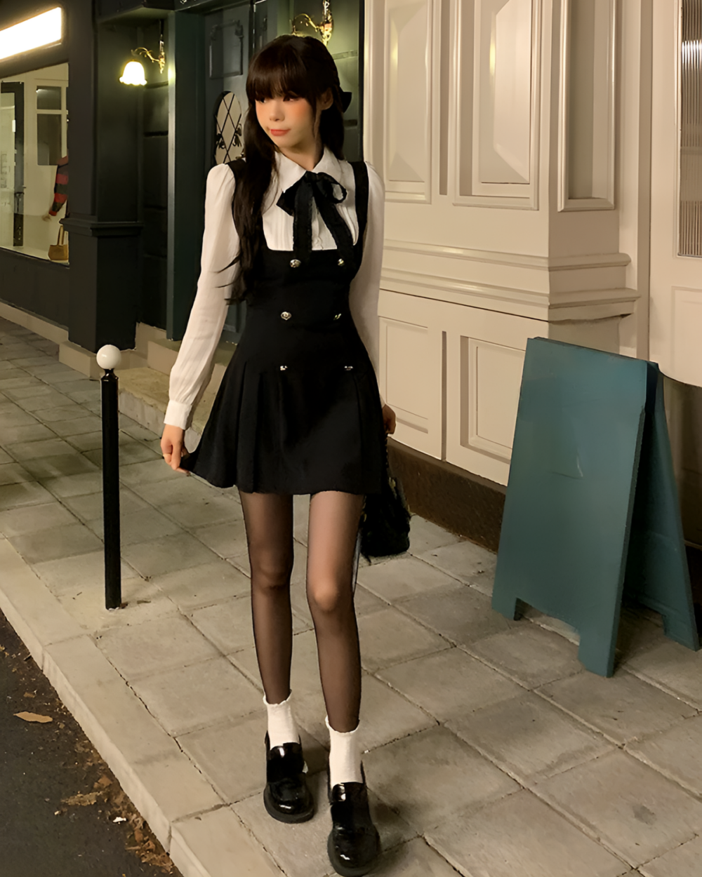 Black fake two-piece dress with a white shirt and black skirt, accessorized with tights and shoes.