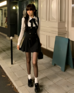 Black fake two-piece dress with a white shirt and black skirt, accessorized with tights and shoes.