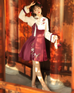Woman wearing a Flowery Wine Dress - Qi Lolita dress in an outdoor setting with ornate pillars.