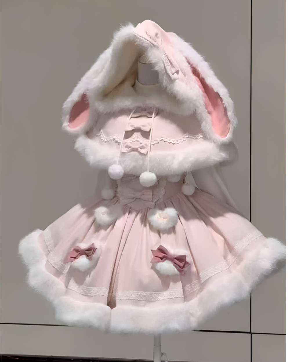 Pink bunnycore dress with a hooded cape and fluffy trim details.