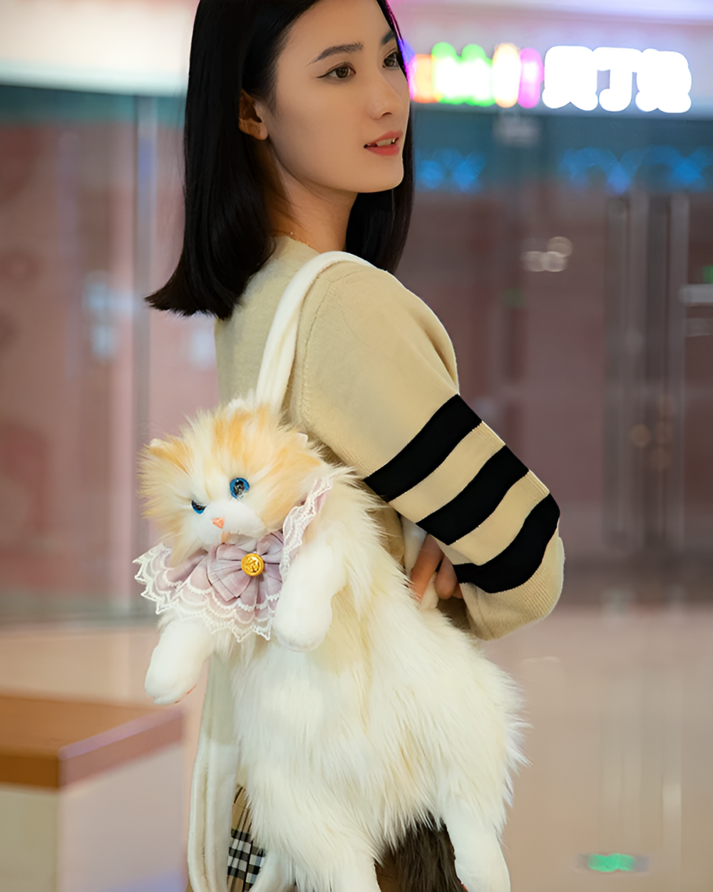 Cute cat backpack featuring a fluffy, white and beige plush design with a decorative button.