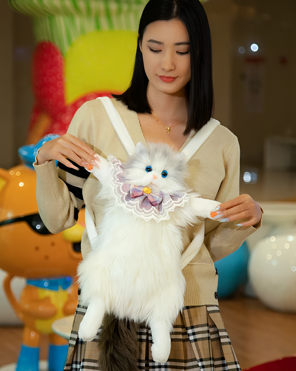 Woman holding a fluffy white cat backpack, the Fluffy Chonker Bag, featuring a bow and embellishments.
