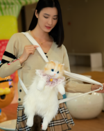 Woman holding a Fluffy Chonker Bag, a cute cat backpack, featuring a plush white cat with pink details.