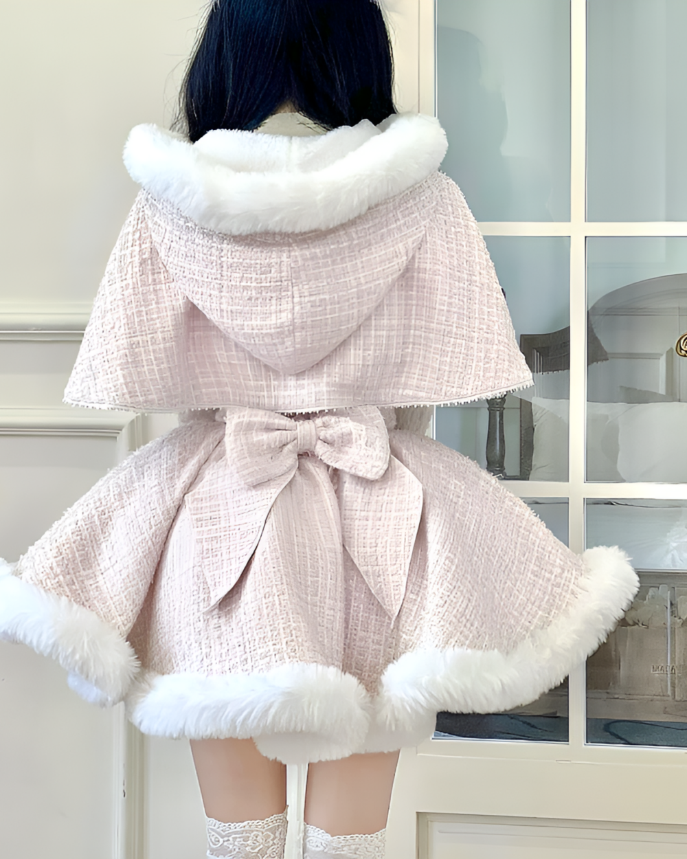 Back view of a pink sweet lolita dress with a white faux fur trim and a bow detail.