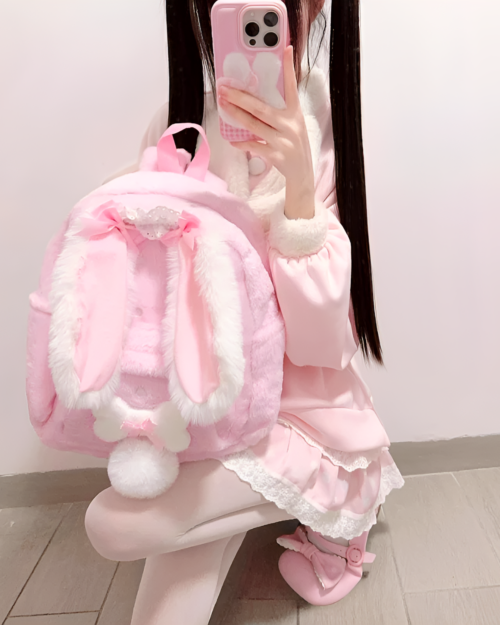 Pink rabbit eared backpack worn by a person.