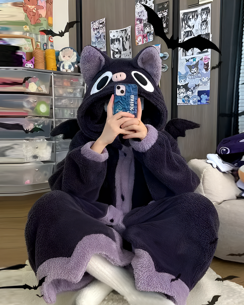 Person wearing a purple Fluffy Kigurumi robe shaped like a bat, sitting and holding a phone.
