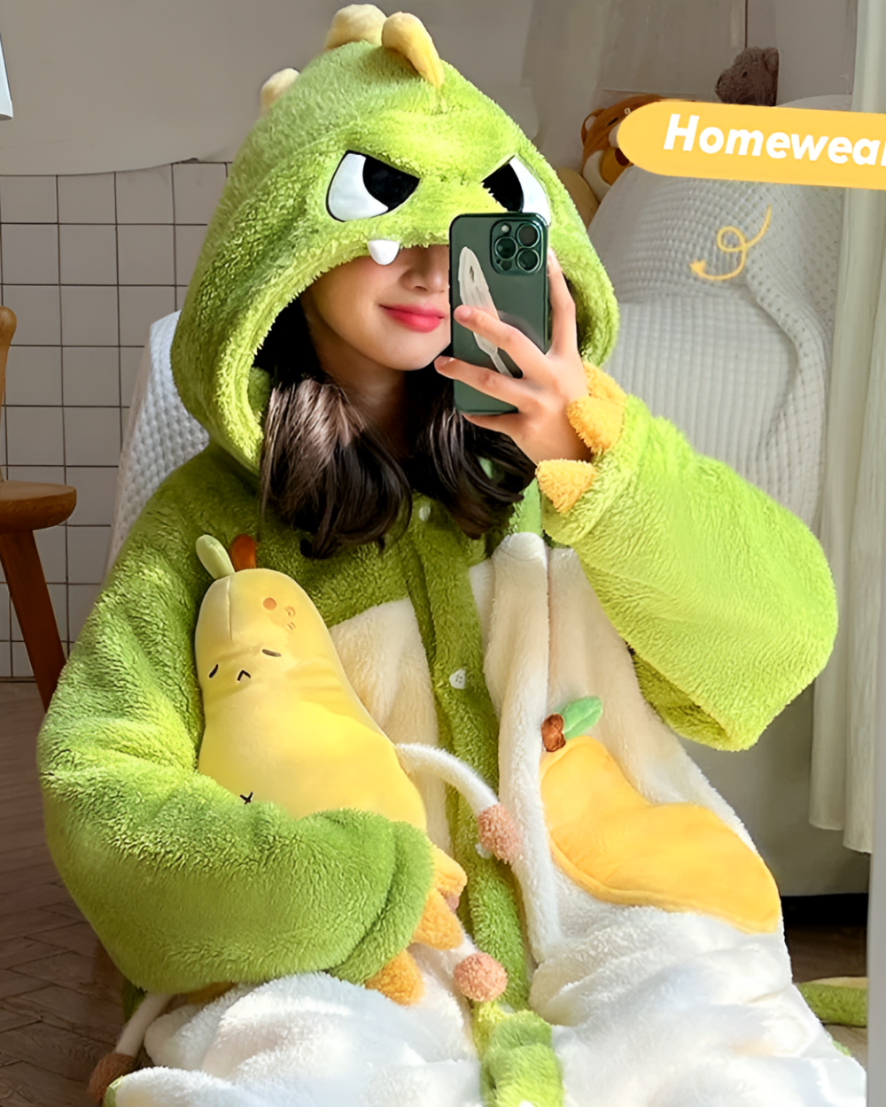 Person wearing a green dinosaur Fluffy Kigurumi robe while holding a phone. Part of the Fluffy Robes Collection.