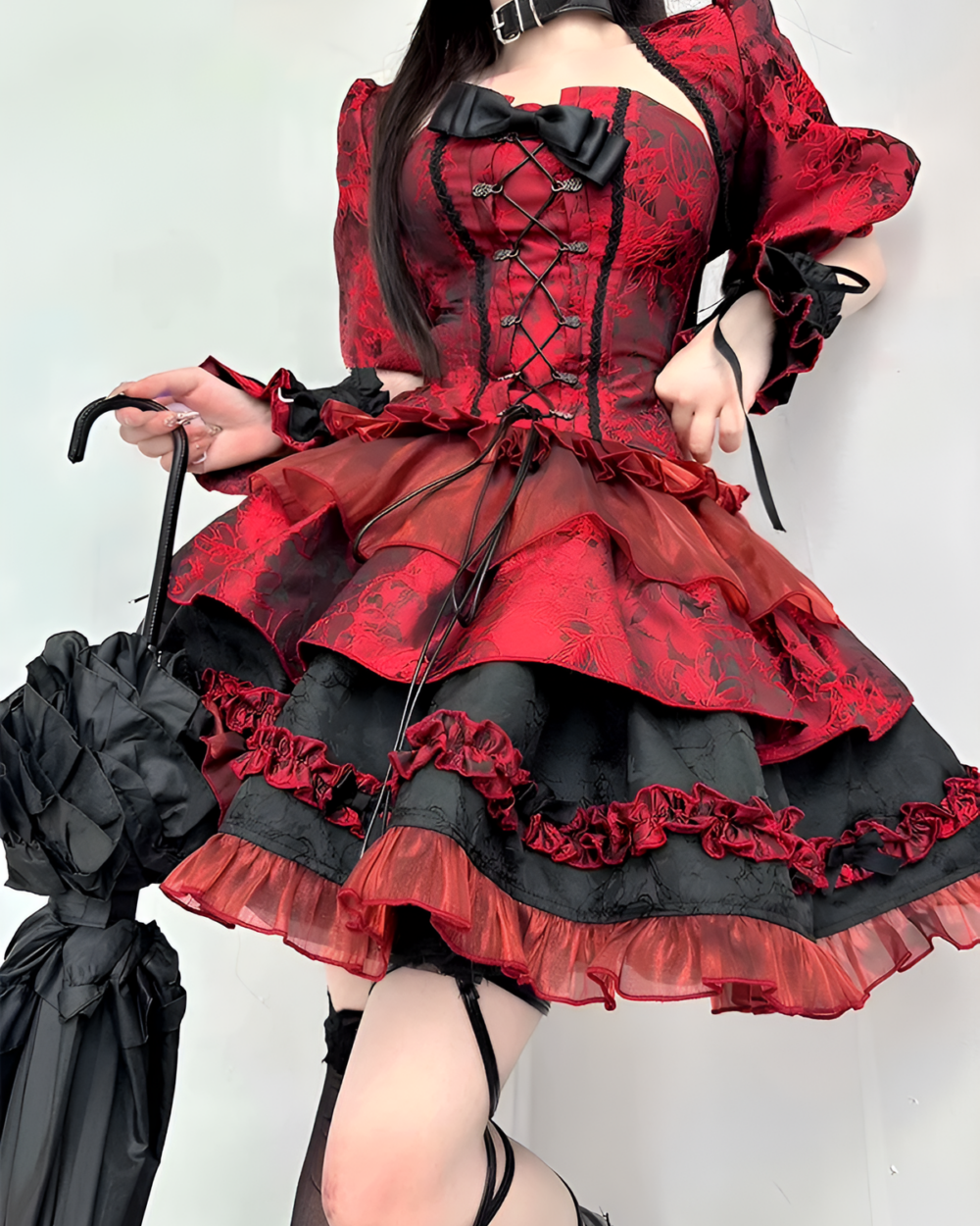 Red and black Gothic Lolita dress with lace, ruffles, and an umbrella.
