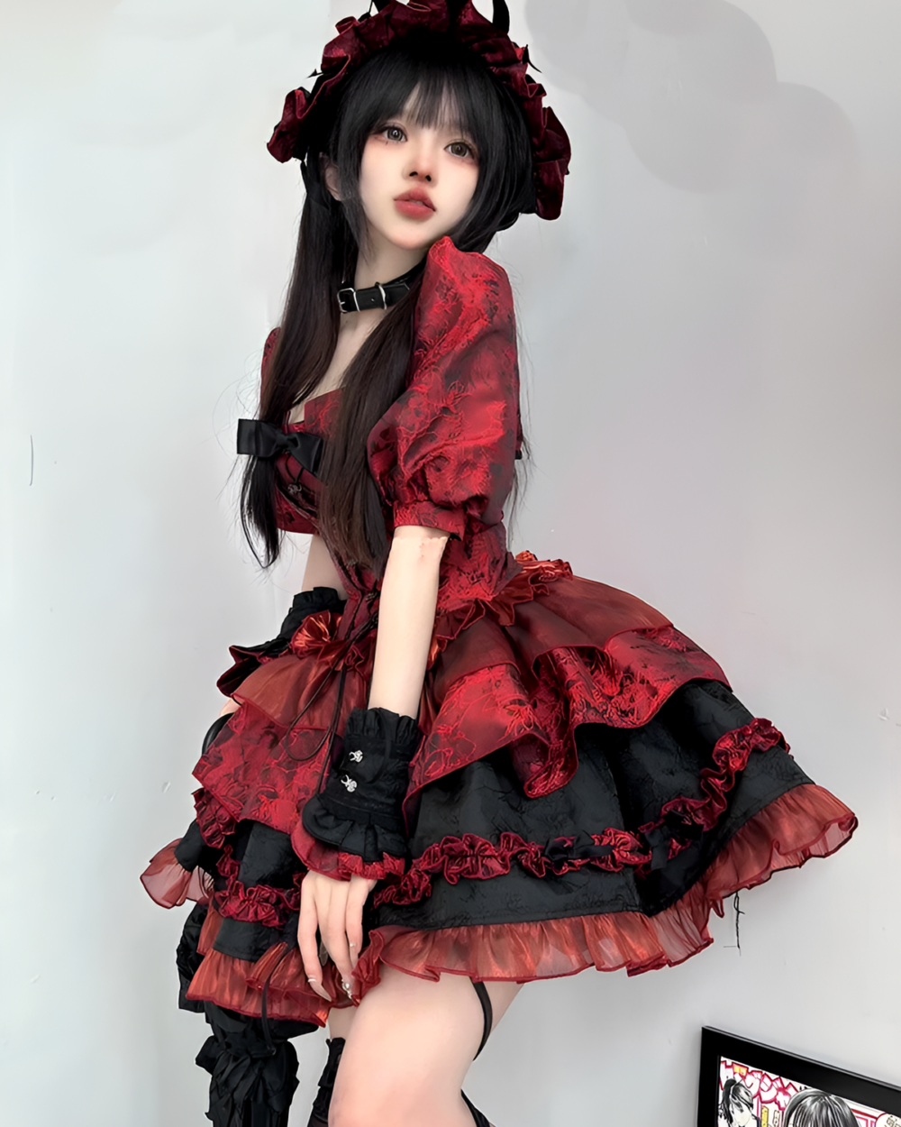 Model wearing a red Gothic Lolita dress with black lace details and a bonnet.