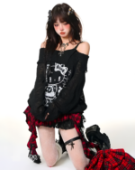 Model wearing a black top and red gothic pleated skirt with white stockings and boots. The gothic pleated skirt features a patchwork design.