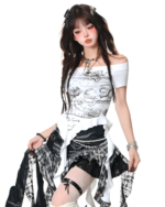 Model wearing a white top and a black and white gothic pleated skirt with patchwork details, paired with boots.