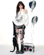 Model wearing a white top and black gothic pleated skirt with patterned tights and platform boots.