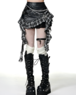Model wearing a black and white checkered gothic pleated skirt with chain detail and lace accents. Includes platform boots.