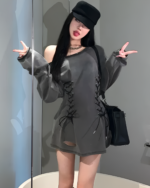 Woman wearing a Grunge-Style Dress, gray oversized shirt with lace detailing, off-shoulder style.