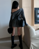 Woman wearing a Grunge-Style Dress, black boots, and a handbag.